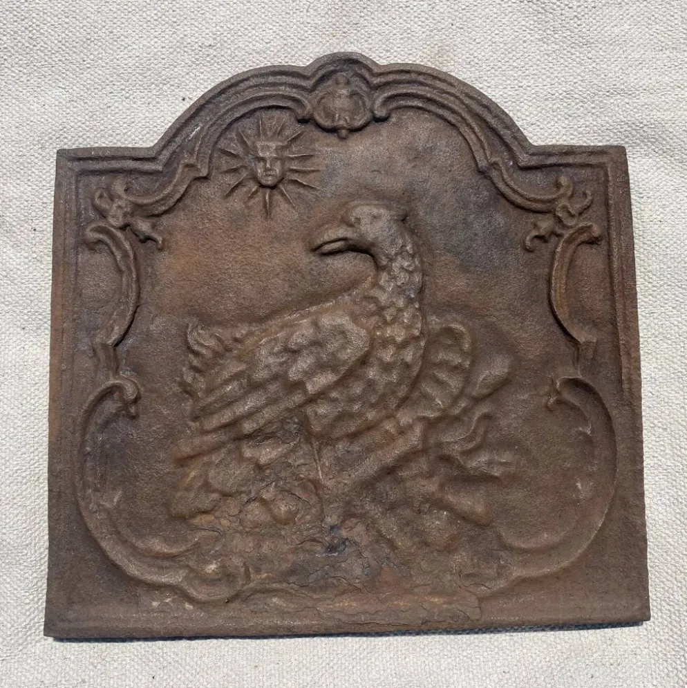 Ancienne plaque de cheminée en fonte ,décor aigle et soleil, 47 × 47 cm