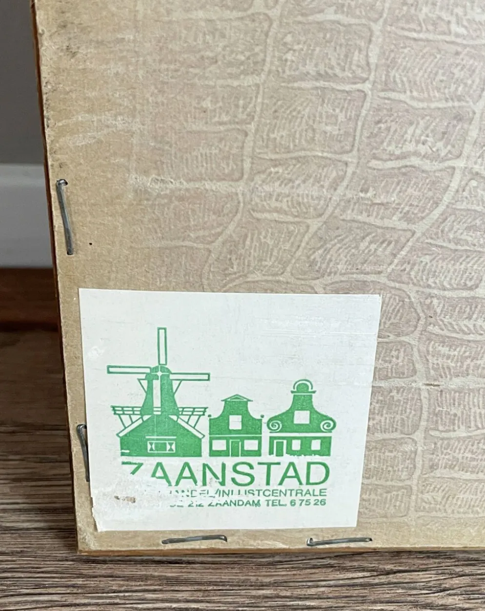 Broderie néerlandaise encadrée représentant une vigne avec des raisins, des bouteilles de vin et des paniers.