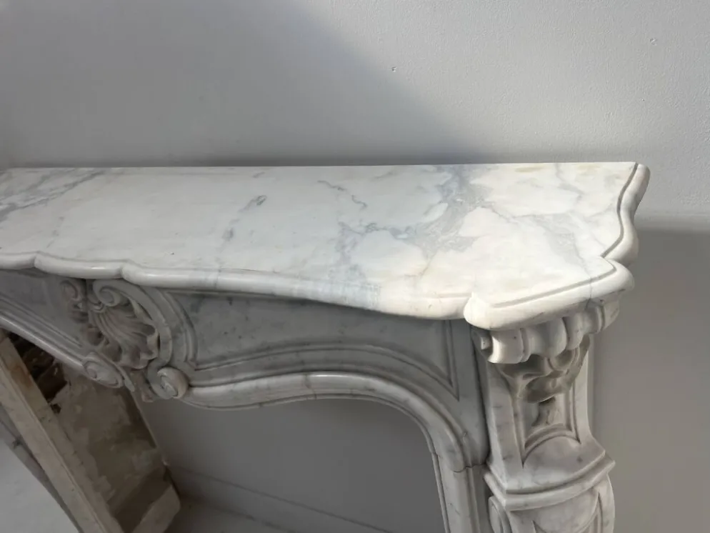 Cheminée de style Louis XV en marbre blanc veiné de Carrare XIX siècle