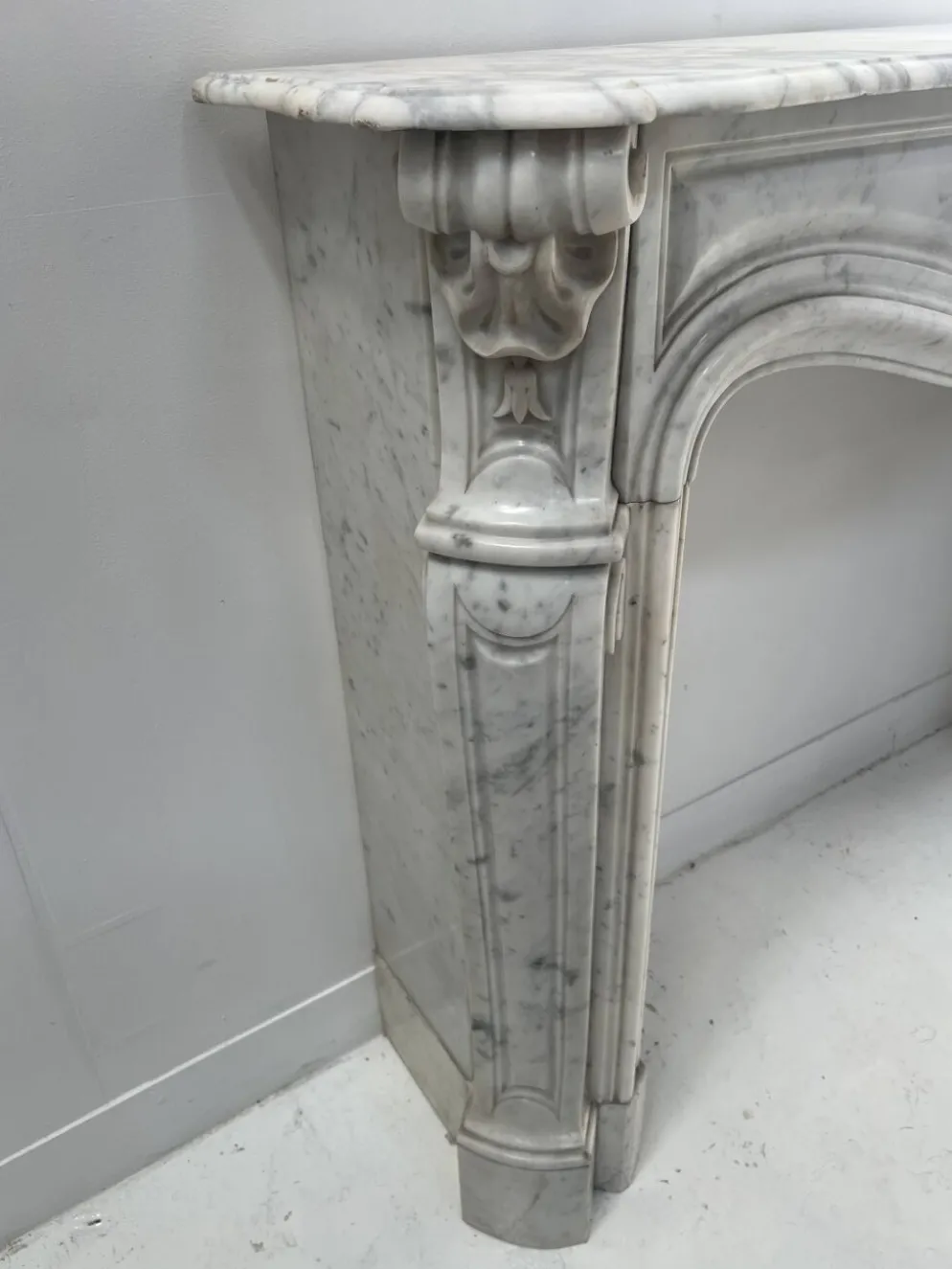 Cheminée de style Louis XV en marbre blanc veiné de Carrare XIX siècle