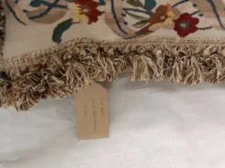 Grand coussin en tapisserie Aubusson de style français avec bouquet de roses et frange à pompons.
