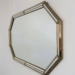 Grand miroir mural octogonal en métal doré espagnol et mosaïque biseautée, style Hollywood Regency.
