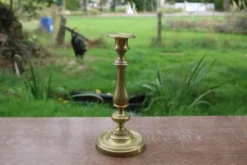 Élégant bougeoir ancien en laiton, à la silhouette élancée et au joli travail de tournage.