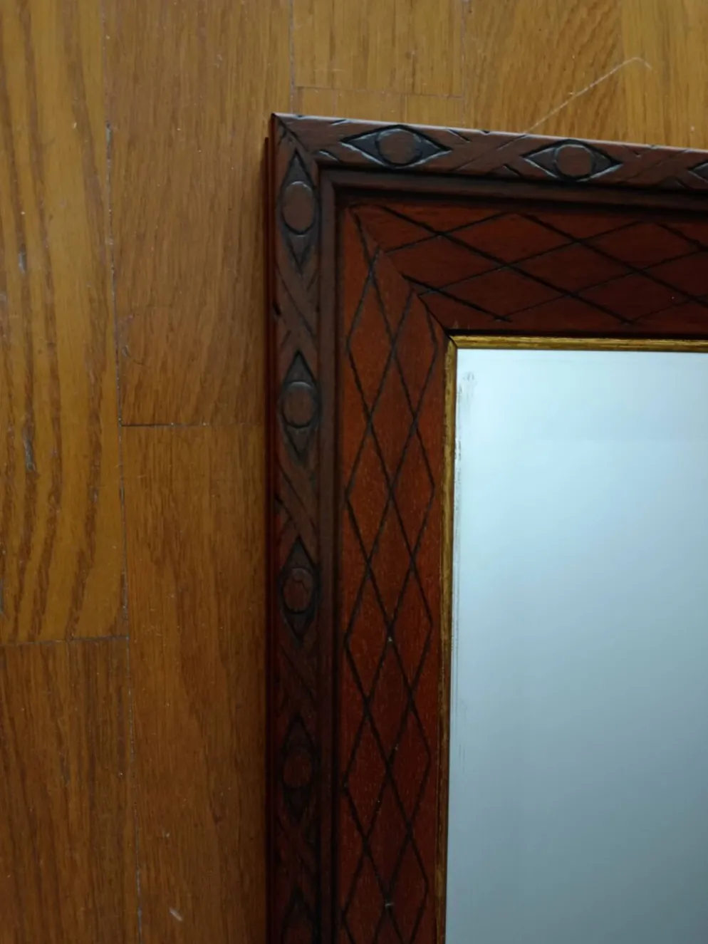Miroir biseauté en bois sculpté et contour doré