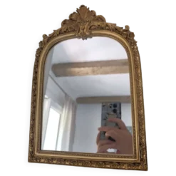 Miroir décoratif avec moulures et fronton.