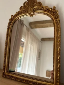 Miroir décoratif avec moulures et fronton.