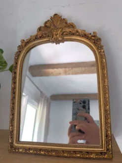 Miroir décoratif avec moulures et fronton.