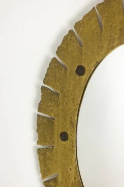 Miroir de forme elliptique en laiton martelé et doré. Années 1950-60.