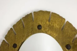 Miroir de forme elliptique en laiton martelé et doré. Années 1950-60.