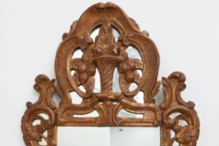 Miroir en bois doré sculpté de style Louis XV avec un fronton floral, France, 18ème siècle.