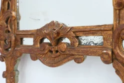 Miroir en bois doré sculpté de style Louis XV avec un fronton floral, France, 18ème siècle.