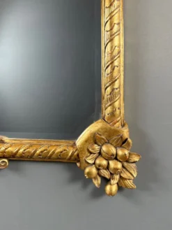 Miroir en bois sculpté et doré à décor de fruits et de fleurs, XXe siècle