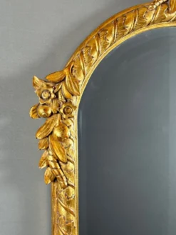 Miroir en bois sculpté et doré à décor de fruits et de fleurs, XXe siècle