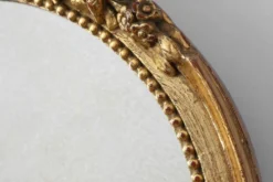 Miroir ovale en bois doré avec un fronton floral de style rococo, milieu du 20e siècle