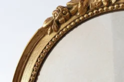 Miroir ovale en bois doré avec un fronton floral de style rococo, milieu du 20e siècle