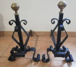 Paire de chenets en fer forgé et boule en laiton.