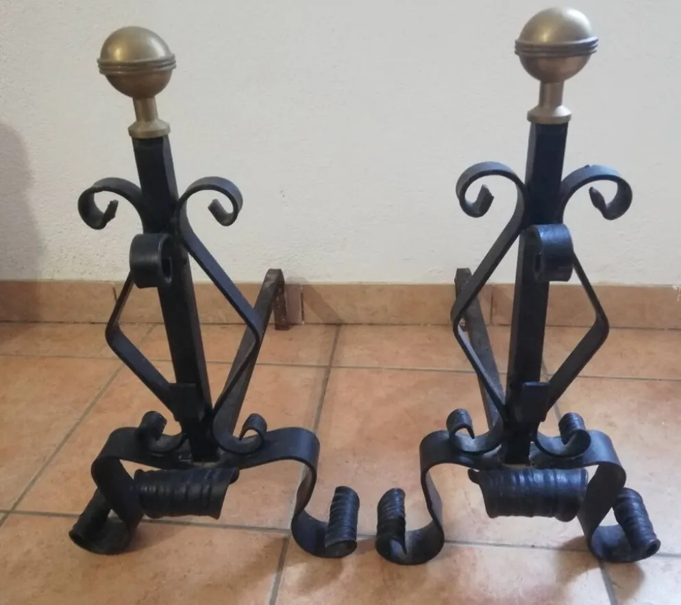 Paire de chenets en fer forgé et boule en laiton.