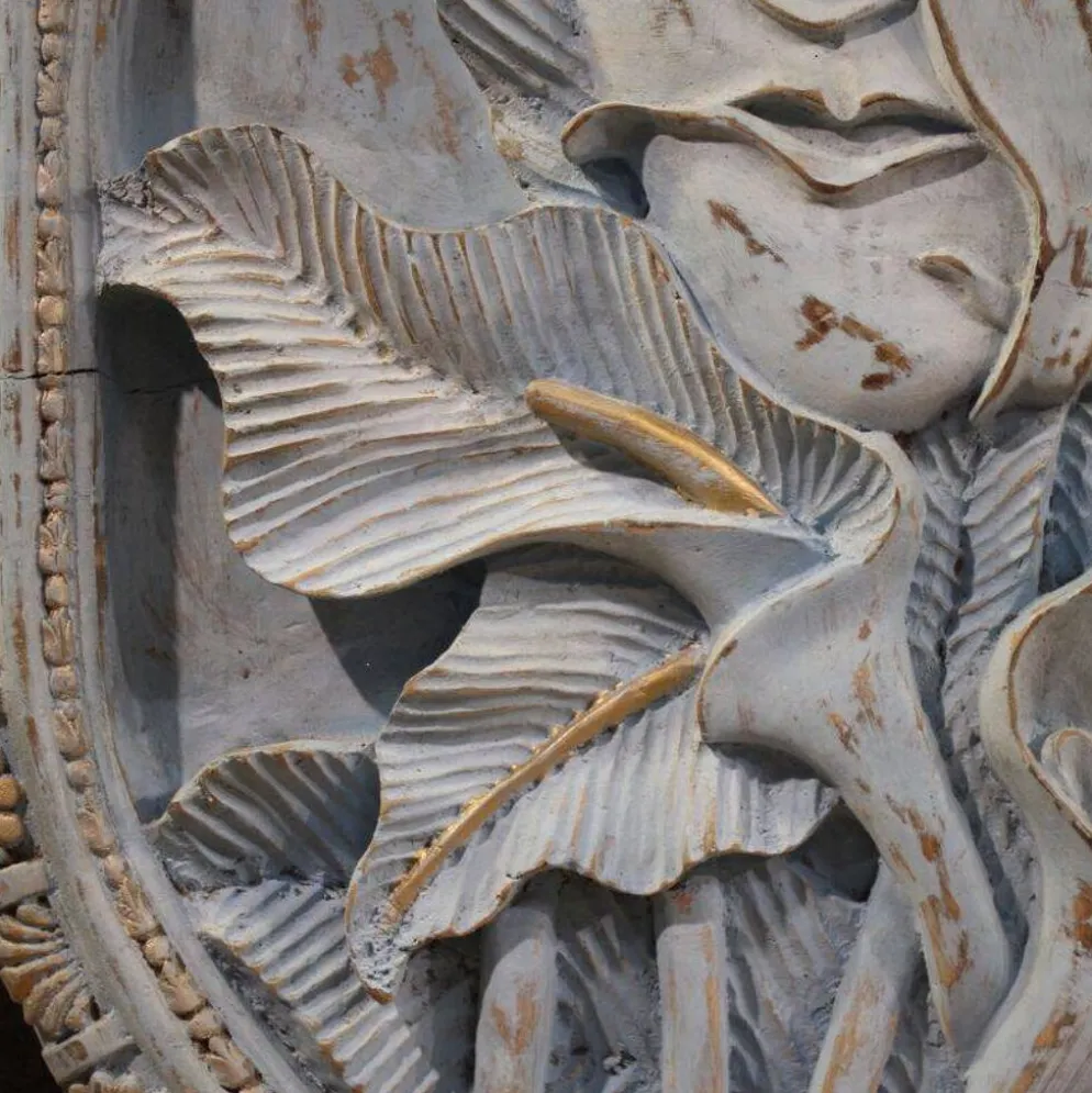 Sculpture en bas-relief, visage stylisé avec des fleurs, 20e siècle