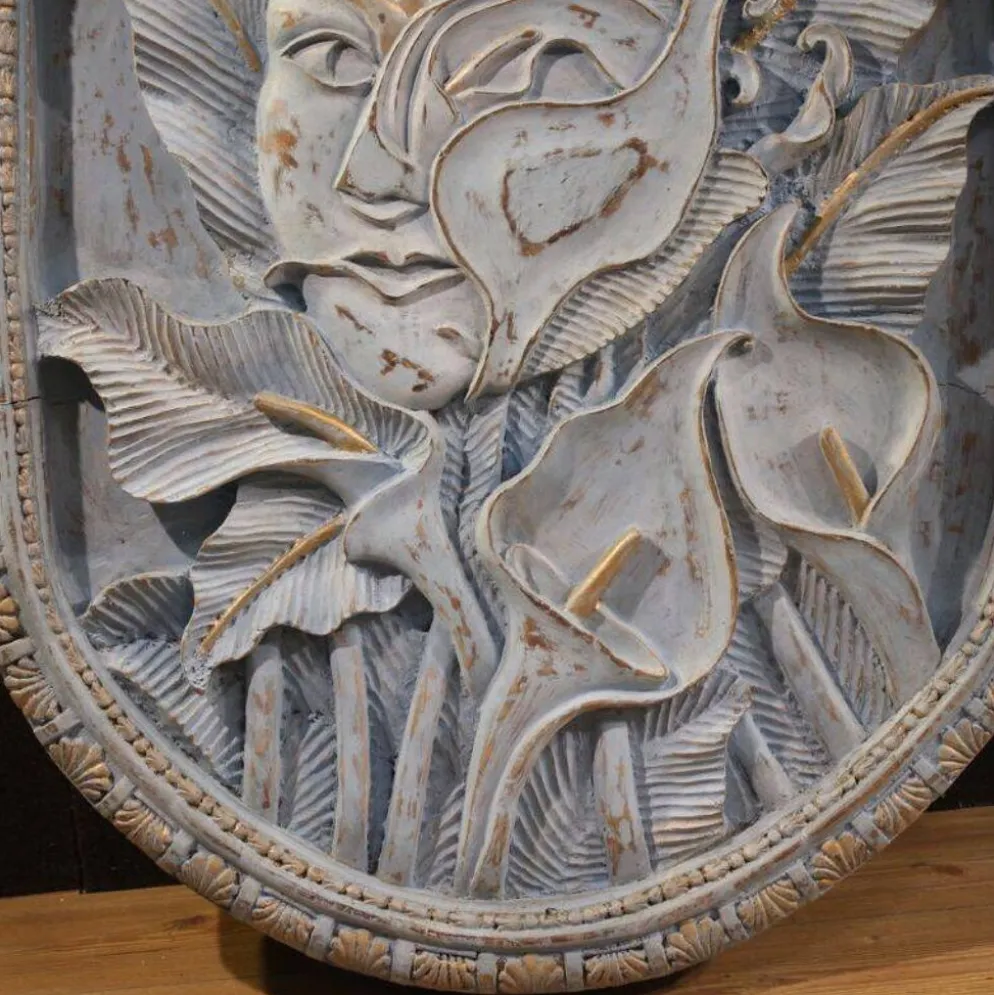 Sculpture en bas-relief, visage stylisé avec des fleurs, 20e siècle
