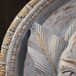 Sculpture en bas-relief, visage stylisé avec des fleurs, 20e siècle