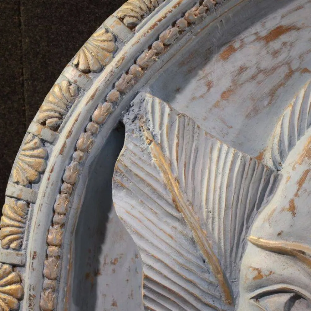 Sculpture en bas-relief, visage stylisé avec des fleurs, 20e siècle