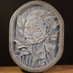 Sculpture en bas-relief, visage stylisé avec des fleurs, 20e siècle