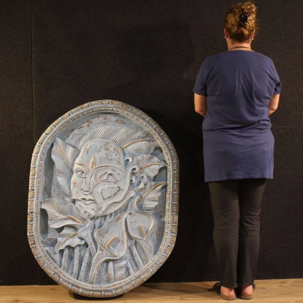 Sculpture en bas-relief, visage stylisé avec des fleurs, 20e siècle