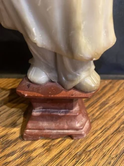 Sculpture en pierre ollaire sur socle en obsidienne d'un bouddhiste.