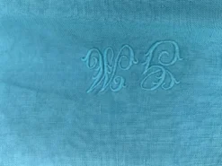 4 serviettes en lin blanc, teintées émeraude, brodées de fleurs et monogrammées, GM anciennes
