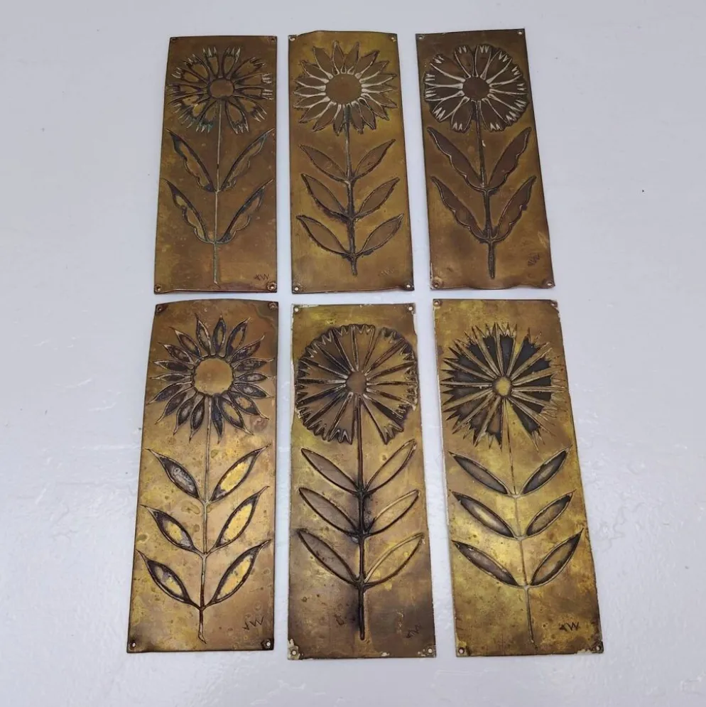 Six plaques de propreté, décor fleurs, laiton