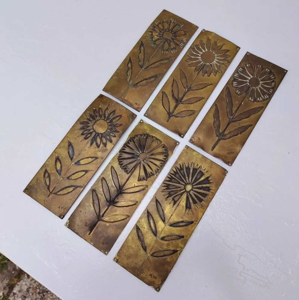 Six plaques de propreté, décor fleurs, laiton