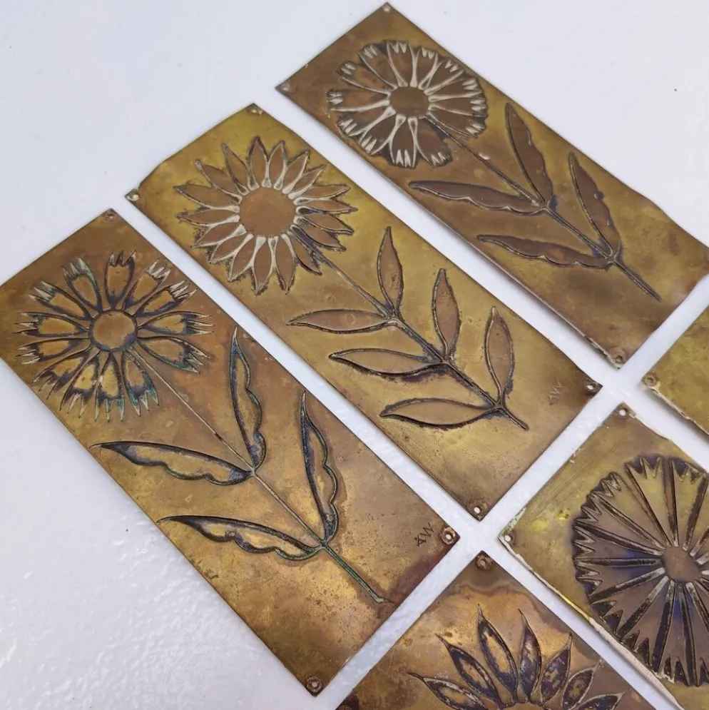 Six plaques de propreté, décor fleurs, laiton