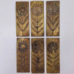 Six plaques de propreté, décor fleurs, laiton