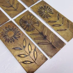 Six plaques de propreté, décor fleurs, laiton