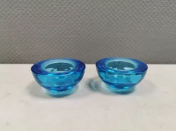 Un ensemble de porte-bougies iittala en verre transparent bleu.