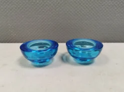 Un ensemble de porte-bougies iittala en verre transparent bleu.