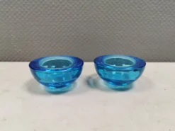 Un ensemble de porte-bougies iittala en verre transparent bleu.